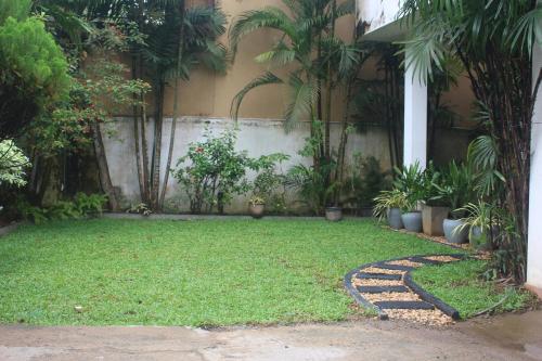 a garden with plants and a stone walkway at Bird's Nest by Natures Bliss in Ragama