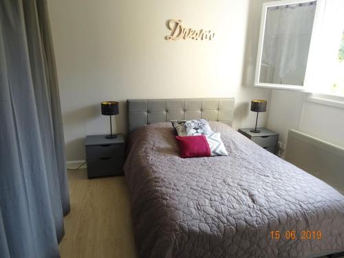 une chambre avec un lit avec deux tables de nuit et deux lampes dans l'établissement Charmant 2 pièces à 500 m des plages et du centre, à Cabourg