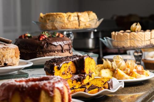 uma mesa coberta com diferentes tipos de bolos e doces em Mar e Mar Florianópolis em Florianópolis