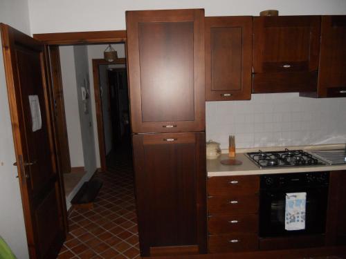 a kitchen with wooden cabinets and a stove at La Fattoria Di Mamma Ro' in Narni