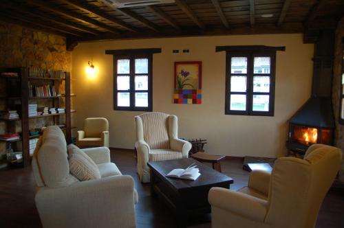 a living room with couches and chairs and a fireplace at Hotel Rural El Fundil in El Pino