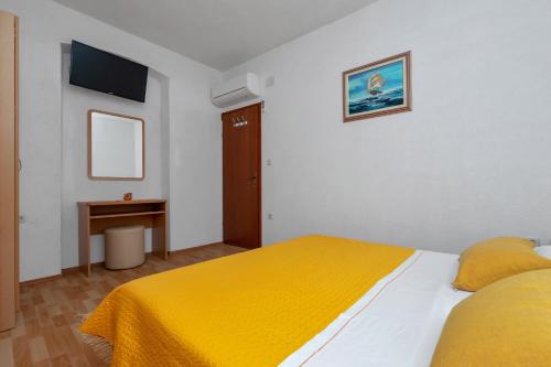 a bedroom with a bed with a yellow blanket at Dado A6 Apartments in Igrane