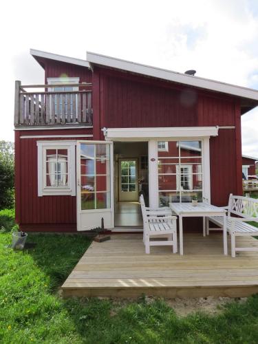 a red house with a deck and a table and chairs at Hotel Kommandørgården in Rømø Kirkeby