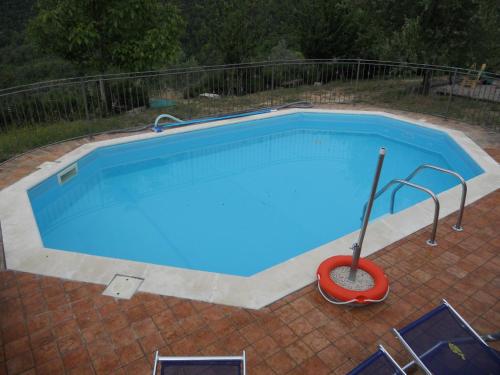 a large swimming pool with a red mop in it at La Fattoria Di Mamma Ro' in Narni