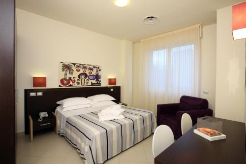 Un pat sau paturi într-o cameră la Noha Suite Hotel