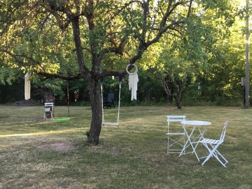 a picnic table and chairs in a park with a tree at Rytterne Kyrkskola in Sorby