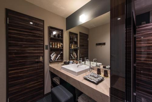 a bathroom with a sink and a large mirror at HOTEL ZEN HIRANO (Adult Only) in Osaka