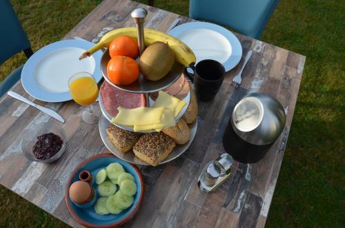een tafel met veel eten erop bij B&B Onder de Molen in Burgh Haamstede