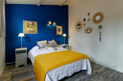 a blue bedroom with a bed with a yellow blanket at Les Coquillages in La Guérinière