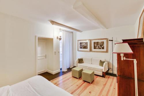 un salon blanc avec un canapé et une table dans l'établissement Unit 008 Saint Germain des Pres (Bac rdc), à Paris