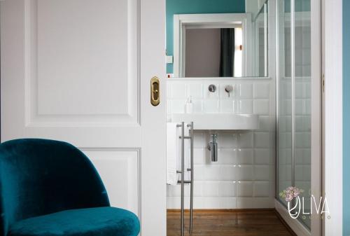 ein Badezimmer mit einem blauen Stuhl und einem Spiegel in der Unterkunft Casa Oliva Quero in Quero