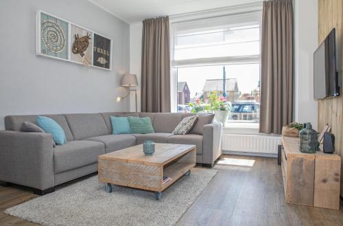 a living room with a couch and a coffee table at Bosruiter De Koog - Texel in De Koog