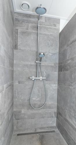 a shower in a bathroom with a stone wall at Bosruiter De Koog - Texel in De Koog