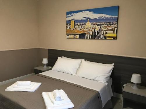 a hotel room with a bed, desk, and painting on the wall at Borgo Palombaio in Catania