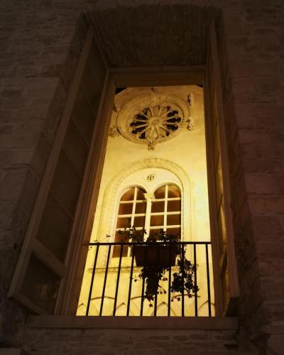 a window in a building with a clock above it at Palazzo Framarino dei Malatesta - Noble Floor - XIV Century in Giovinazzo