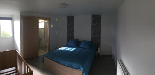 ein Schlafzimmer mit einem Bett mit blauen Kissen in der Unterkunft chez juliette in Mauléon
