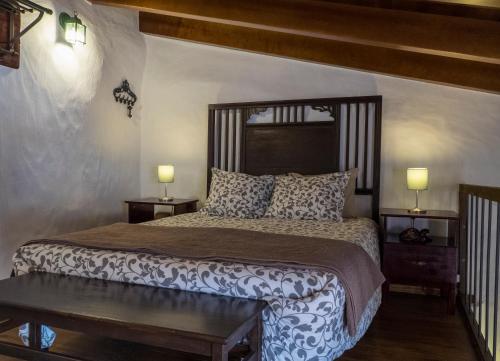a bedroom with a large bed with two lamps on it at La Bohemia Apartments in Teror