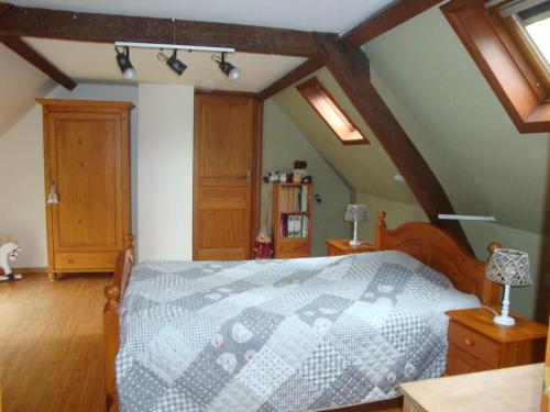 - une chambre avec un lit, du parquet et des plafonds en bois dans l'établissement Le Clos des Hirondelles, à Petit Baisieux