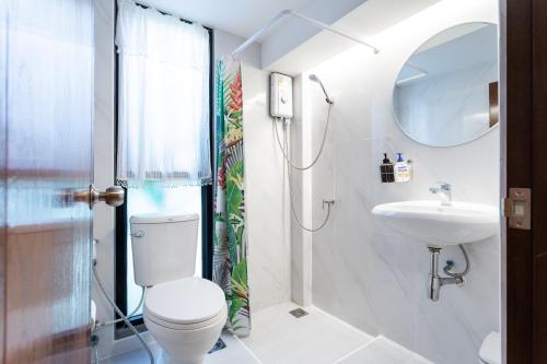 a bathroom with a toilet and a sink at Baan Boon in Bangkok