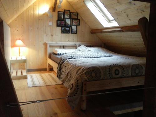 um quarto com uma cama num chalé de madeira em le chalet em Theys