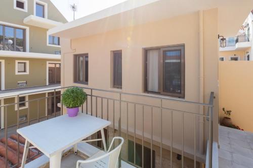 uma varanda com uma mesa e um vaso de plantas em Aura central apartments em Argostoli