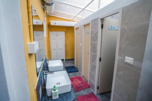łazienka z 2 umywalkami i 2 toaletami w obiekcie Roambay w mieście Mysuru
