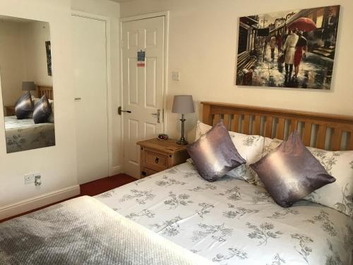 a bedroom with a bed and a painting on the wall at Bridge Farm Hotel in Leeds