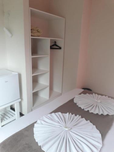 two white umbrellas on the floor in a room at HsHotelaria - Filial Bombinhas in Bombinhas