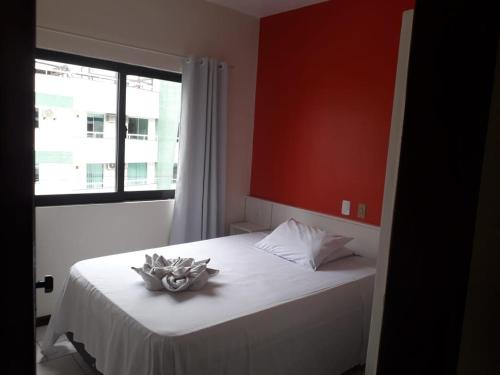 a room with a bed with a flower on it at HsHotelaria - Filial Bombinhas in Bombinhas