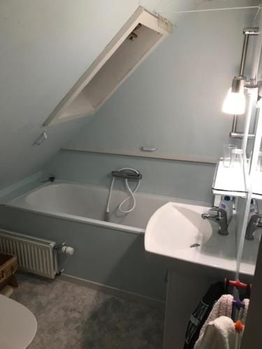 a bathroom with a sink and a bath tub at Det lille gule hus in Trongisvágur