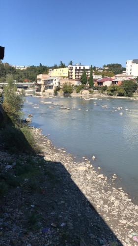 a river with buildings on the side of it at Apartment Riverside in Kutaisi