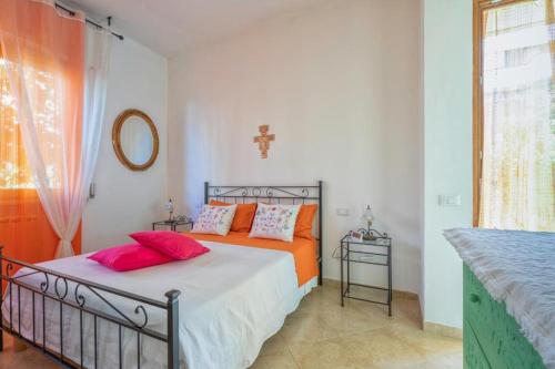 ein Schlafzimmer mit einem Bett mit orangefarbenen Kissen und einem Fenster in der Unterkunft Casa di Marina in Viareggio