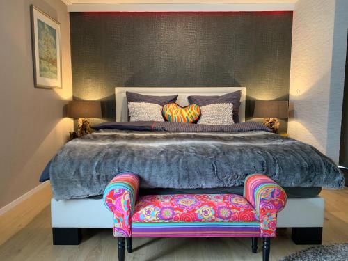 - une chambre avec un grand lit et une chaise dans l'établissement Waldstudio Comfort, à Simmerath