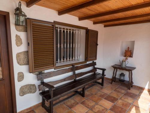 a wooden bench in a room with a window at La Bohemia Apartments in Teror