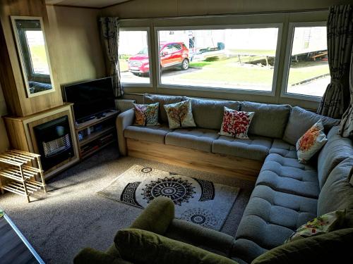 a living room with a couch and a television at Pebble Bay Retreat in Milford on Sea