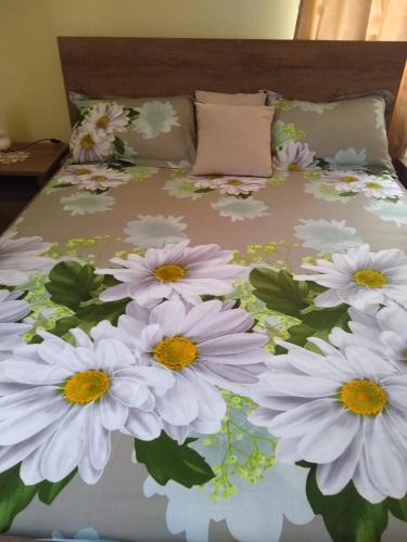 a bed with a bunch of white flowers on it at Olimpia Apartments in Alba Iulia