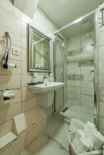 a bathroom with a sink and a shower and a mirror at Mini Hotel Ryleev in Kharkiv