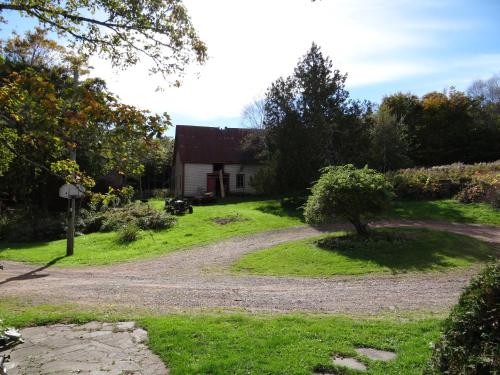 a house in the middle of a field with a dirt road at Chamcook Forest Lodge Bed & Breakfast in Saint Andrews