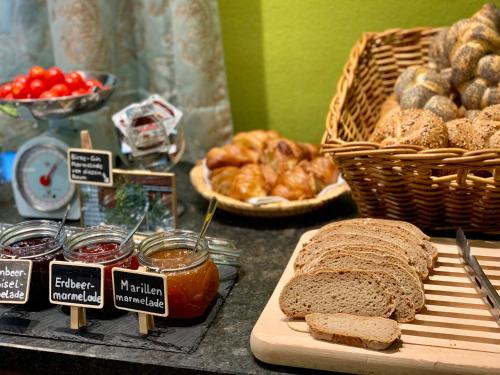 a table with bread and jam and baskets of bread at Das Franzl - Bett & Brot in St. Wolfgang
