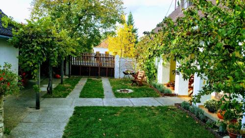 a backyard with a garden with a fence and trees at Derű Vendégház és Lovasudvar in Fenyőfő