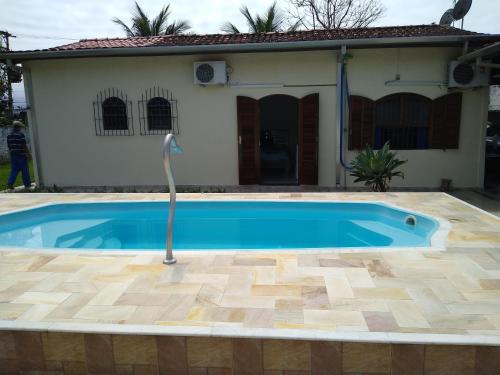a swimming pool in front of a house at Suíte em Caraguá in Caraguatatuba