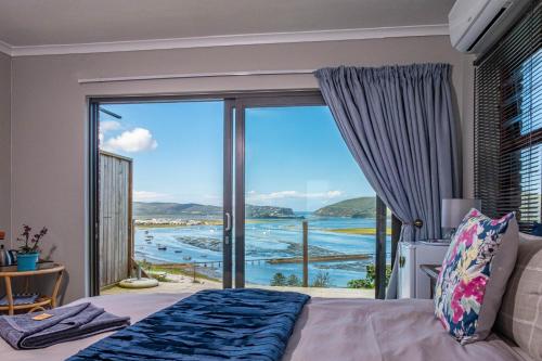 a bedroom with a bed and a large window at Paradise Found in Knysna
