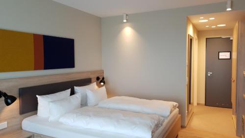 a bedroom with a bed with white pillows at Die Sandburg in Langeoog