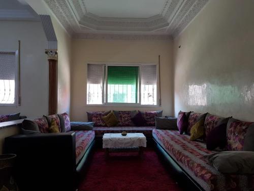 a living room with a couch and a table at Joli Appartement Meublé à Rte Ain Chkef in Fez
