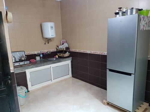 uma cozinha com um frigorífico branco num quarto em Joli Appartement Meublé à Rte Ain Chkef em Fez