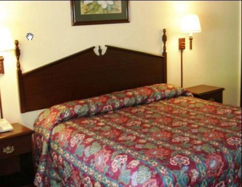 a hotel room with a bed with a red comforter at Scottish Inn Maggie Valley in Maggie Valley