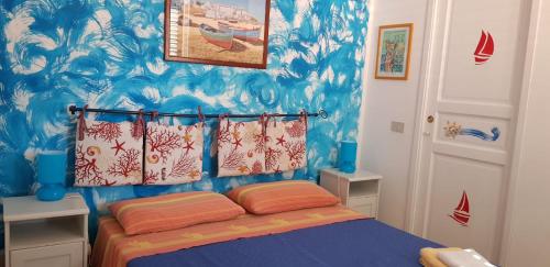 a bedroom with a bed with a blue wall at La Caletta in Santa Flavia