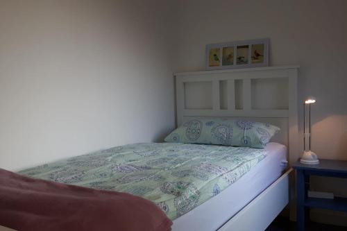 ein Schlafzimmer mit einem Bett und einem Tisch mit einer Lampe in der Unterkunft Ferienwohnung an der Südheide 80 qm max 4 Personen in Dedelstorf