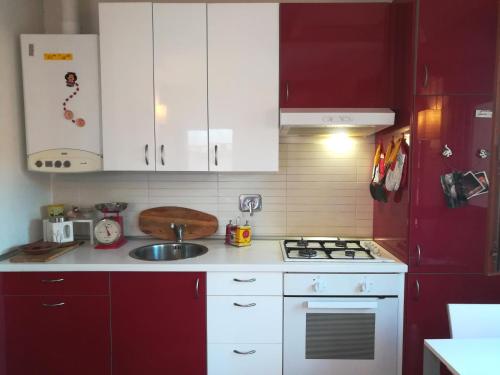 eine Küche mit weißen Schränken und einem roten Kühlschrank in der Unterkunft Casamia in Bologna