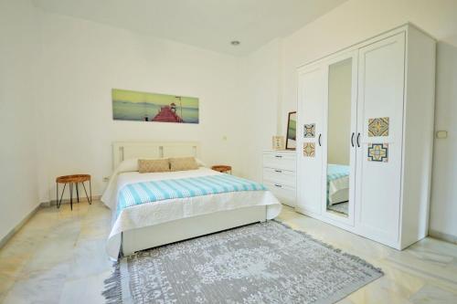 1 dormitorio blanco con 1 cama y vestidor en VILLA BAHIA AZUL, en Estepona